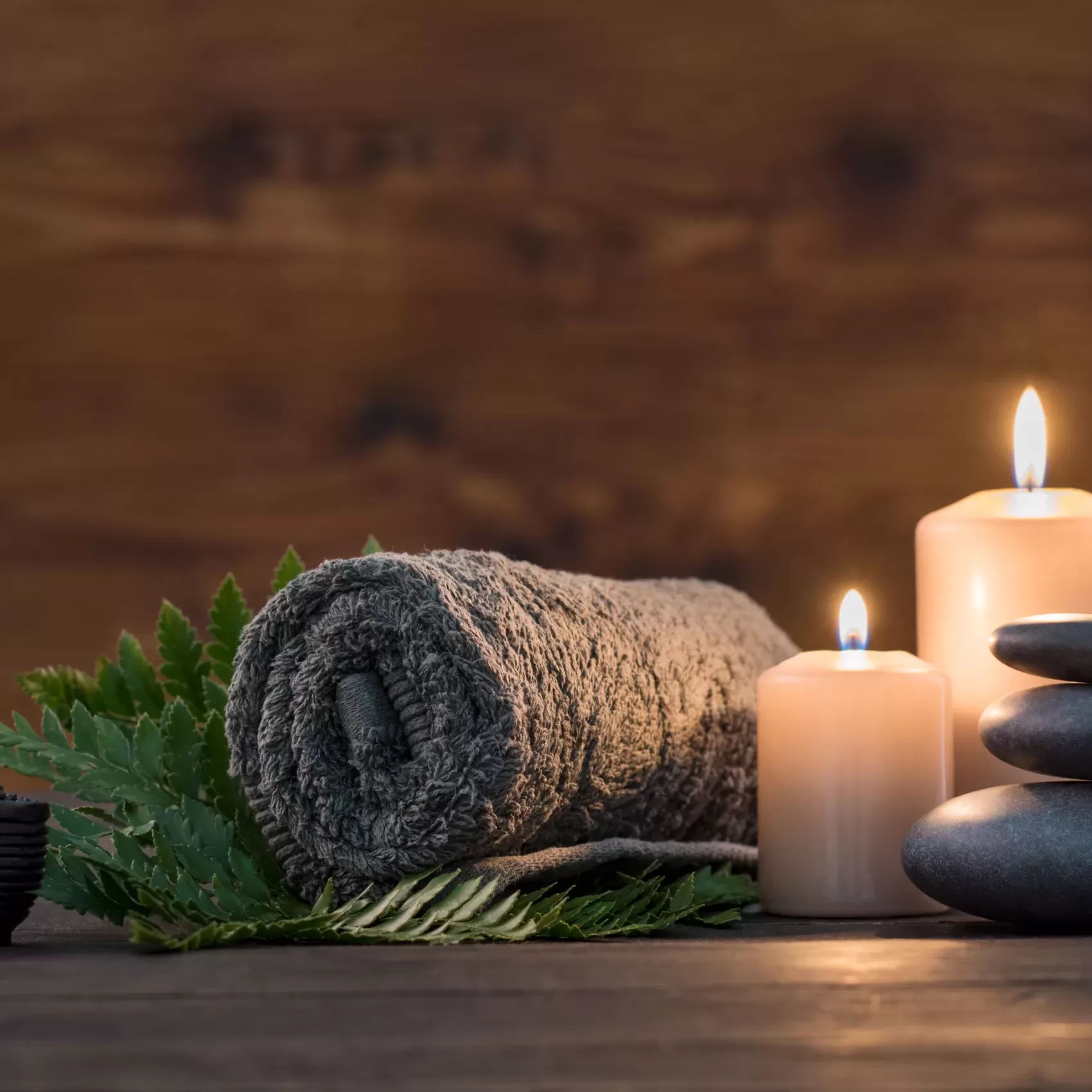 Towel,On,Fern,With,Candles,And,Black,Hot,Stone,On