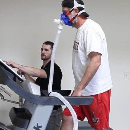 Man undergoing metabolic testing with mask and treadmill for health assessment.